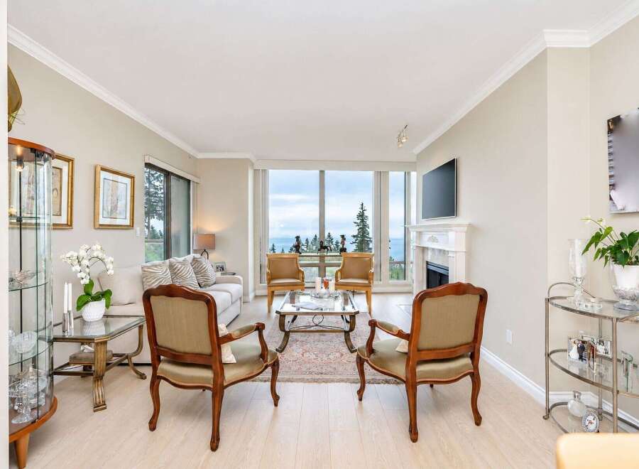Experience breathtaking ocean views from this elegant living room, featuring a cozy fireplace and a large picture window.