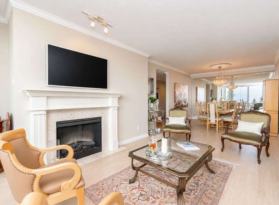 Experience elegant living in this spacious open-concept home, featuring a modern fireplace and a large flat-screen TV.
