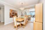 Experience elegant dining in this beautifully appointed space, featuring a large wooden table surrounded by upholstered chairs.