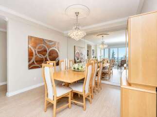 Experience elegant dining in this beautifully appointed space, featuring a large wooden table surrounded by upholstered chairs.