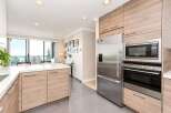 Experience modern living in this stunning kitchen featuring sleek, light wood cabinetry and a spacious white quartz island, perfect for meal preparation and casual dining.