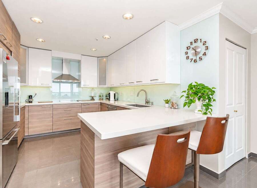 Experience modern living in this stunning kitchen featuring sleek white cabinetry and warm wood accents.