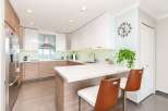 Experience modern living in this stunning kitchen featuring sleek white cabinetry and warm wood accents.