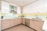 Experience modern luxury in this stunning kitchen, featuring sleek white cabinetry and warm wood lower cabinets.