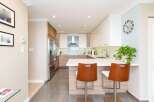 Experience modern living in this stunning kitchen featuring sleek white cabinetry, warm wood accents, and a spacious island perfect for entertaining.