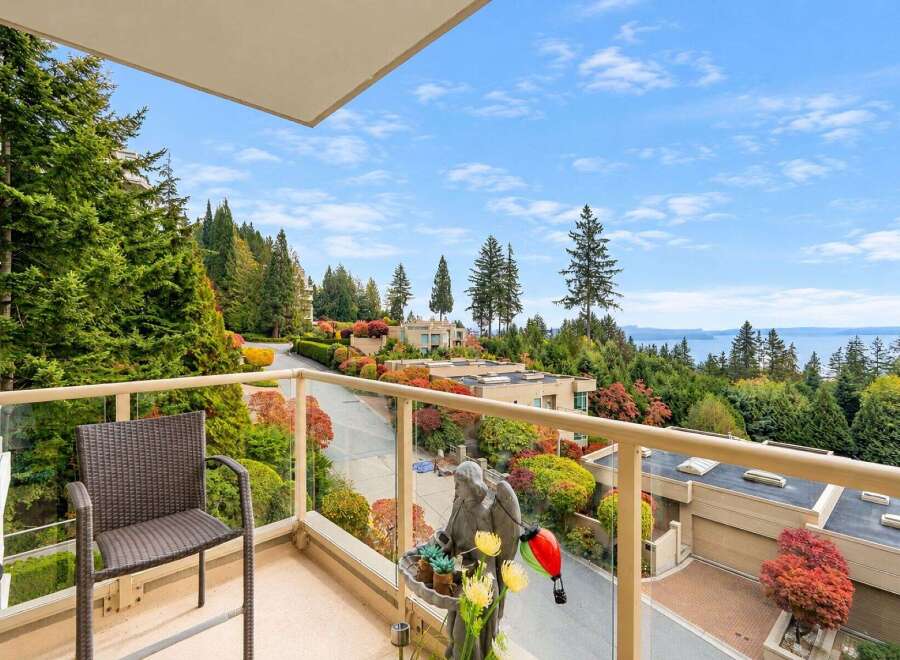 Enjoy breathtaking panoramic views of the water and lush greenery from this stunning balcony.