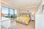 Experience breathtaking ocean views from this stunning bedroom, featuring a luxurious king-size bed with vibrant yellow floral bedding.