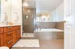 Experience luxury in this modern bathroom featuring a spacious glass-enclosed shower with tiled walls and a pebble floor.