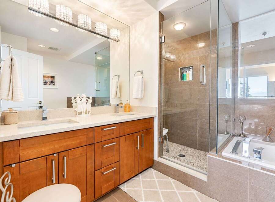 Experience luxury in this stunning bathroom featuring a spacious walk-in shower with pebble flooring and a sleek glass enclosure.