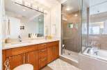 Experience luxury in this stunning bathroom featuring a spacious walk-in shower with pebble flooring and a sleek glass enclosure.