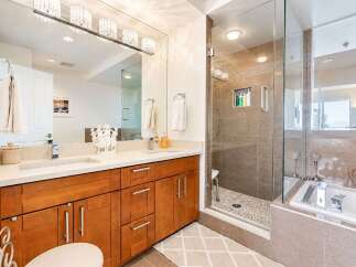 Experience luxury in this stunning bathroom featuring a spacious walk-in shower with pebble flooring and a sleek glass enclosure.