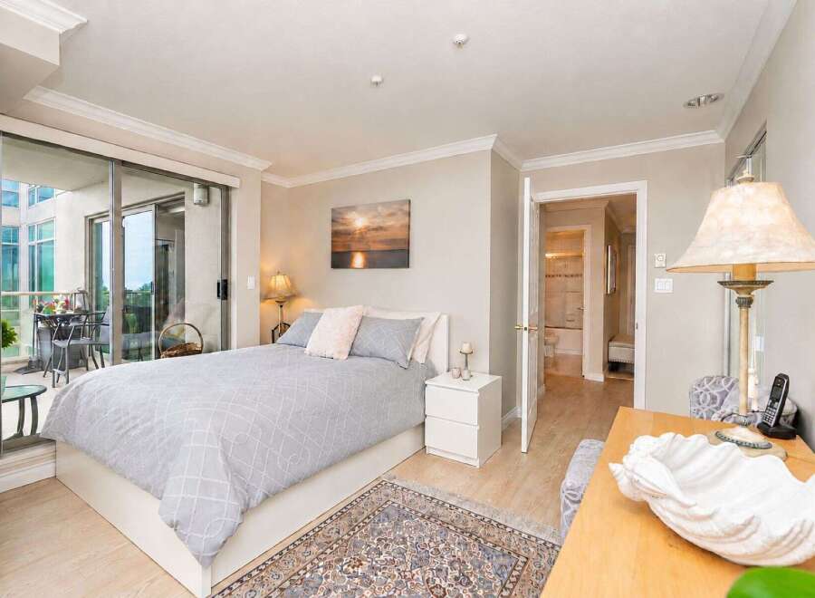This inviting bedroom features a comfortable queen-size bed with a stylish grey patterned duvet and plush pink pillows.