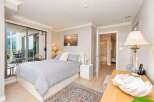 This inviting bedroom features a comfortable queen-size bed with a stylish grey patterned duvet and plush pink pillows.