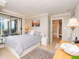 This inviting bedroom features a comfortable queen-size bed with a stylish grey patterned duvet and plush pink pillows.