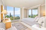 Experience breathtaking panoramic views from this stunning bedroom, featuring floor-to-ceiling windows that showcase the serene water and lush greenery.