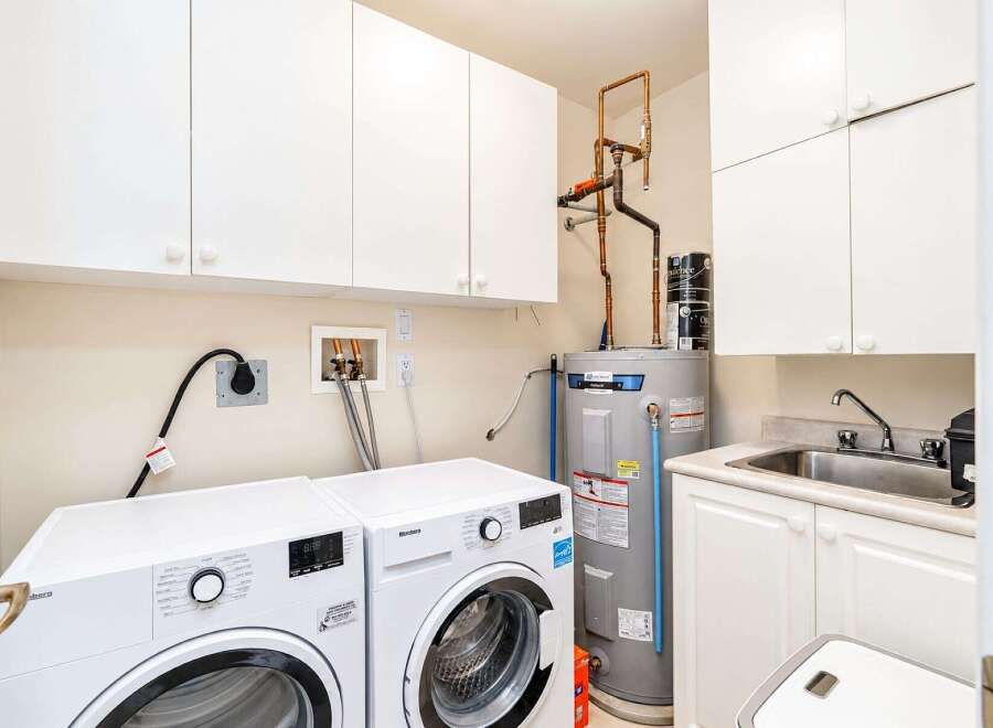 This laundry room boasts a full-sized washer and dryer, ensuring ample space for all your laundry needs.