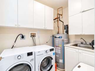 This laundry room boasts a full-sized washer and dryer, ensuring ample space for all your laundry needs.