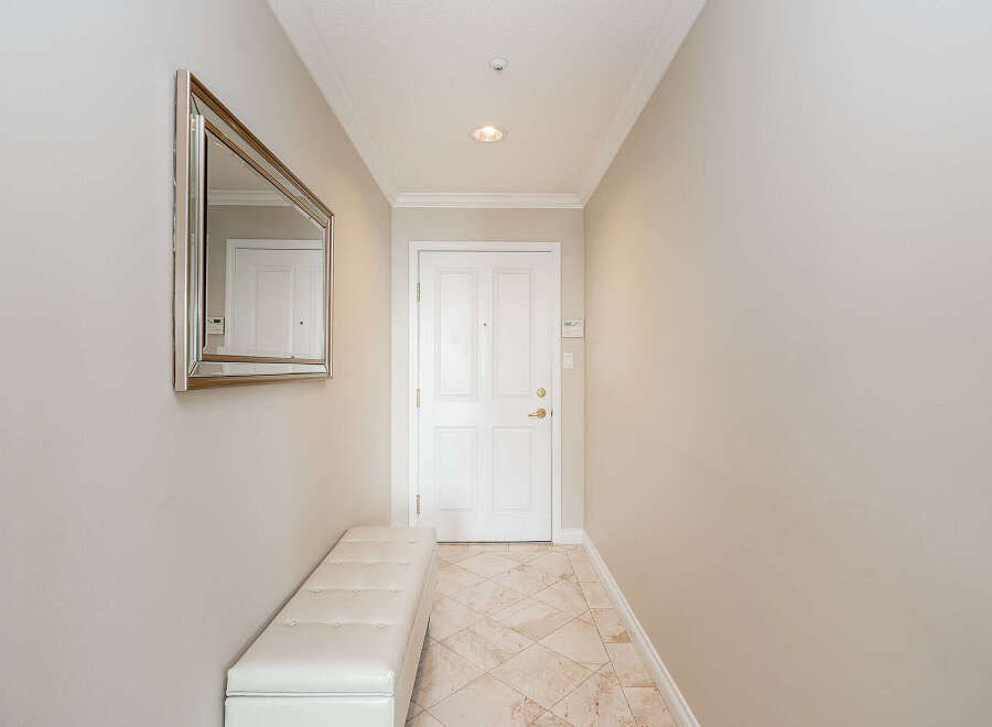 Step into this welcoming entryway, featuring a stylish tufted bench perfect for removing shoes.