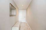 Step into this welcoming entryway, featuring a stylish tufted bench perfect for removing shoes.