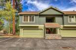 This charming property features a two-story design with a light green exterior and a complementary tan trim.