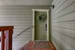 Welcome guests with this charming front entrance, featuring a classic green door adorned with a lush wreath.