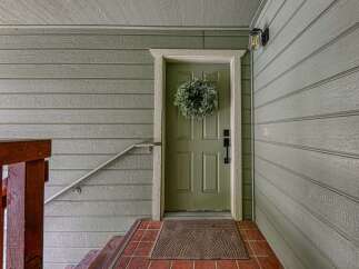Welcome guests with this charming front entrance, featuring a classic green door adorned with a lush wreath.