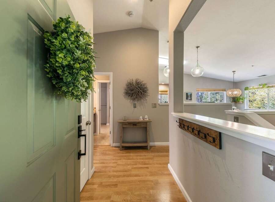 Step into a welcoming entryway featuring a light green door adorned with a lush green wreath.