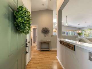 Step into a welcoming entryway featuring a light green door adorned with a lush green wreath.