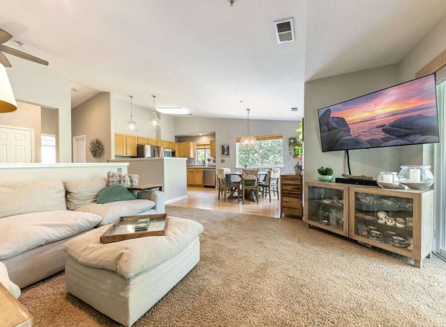 Experience open-concept living in this beautifully appointed home, featuring a spacious living area seamlessly flowing into a modern kitchen and dining space.