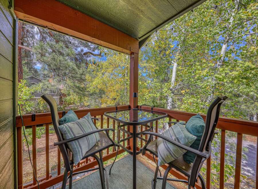 Enjoy your morning coffee or evening drinks on this charming balcony, complete with a glass-top table and two comfortable chairs adorned with decorative pillows.