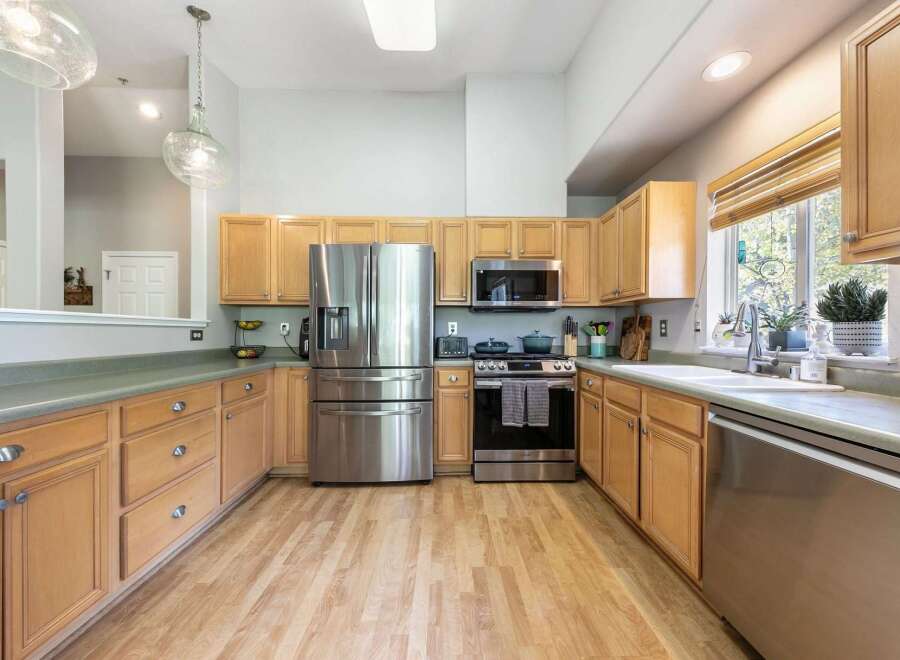 This spacious kitchen boasts beautiful light wood cabinetry, offering ample storage and a warm, inviting aesthetic.