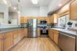 This spacious kitchen boasts beautiful light wood cabinetry, offering ample storage and a warm, inviting aesthetic.