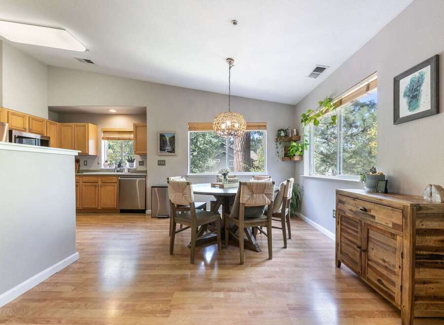 This spacious dining area features a round wooden table with four chairs, perfect for intimate gatherings.