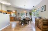 This spacious dining area features a round wooden table with four chairs, perfect for intimate gatherings.