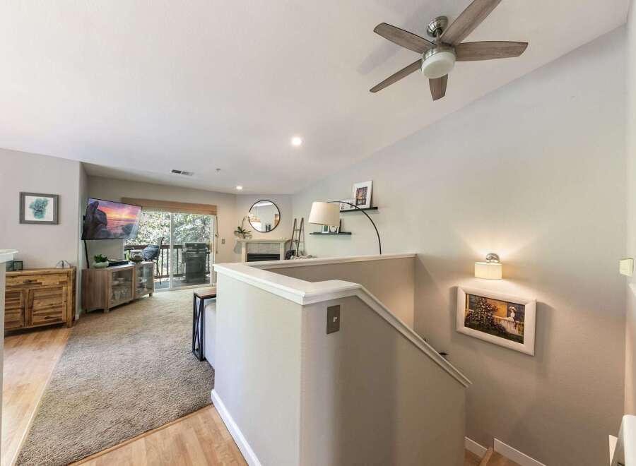 Step into this inviting living space featuring a large flat-screen TV, a cozy fireplace, and a private balcony perfect for outdoor relaxation.