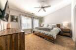 Experience comfort and style in this inviting bedroom, featuring a plush king-size bed with a cozy gray duvet and a rustic wooden frame.