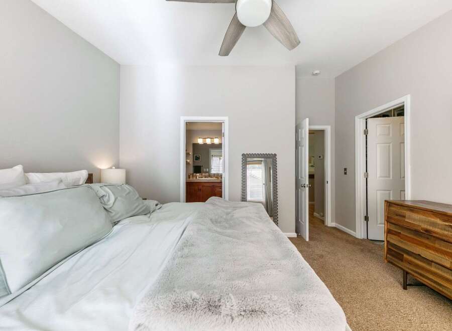 Step into this inviting bedroom featuring a plush bed with soft, light blue linens and a cozy faux fur throw.