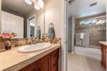 This bathroom features a spacious vanity with a white undermount sink and a tiled backsplash.