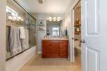 This bathroom features a spacious bathtub with a glass enclosure and convenient towel racks.