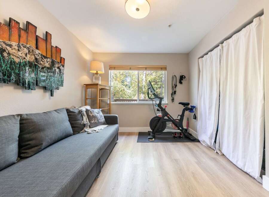 This versatile room offers a comfortable living space with a plush grey sofa, perfect for relaxing after a workout.
