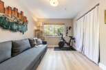 This versatile room offers a comfortable living space with a plush grey sofa, perfect for relaxing after a workout.