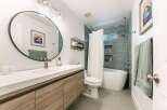 This modern bathroom features a sleek vanity with ample storage and a minimalist aesthetic.