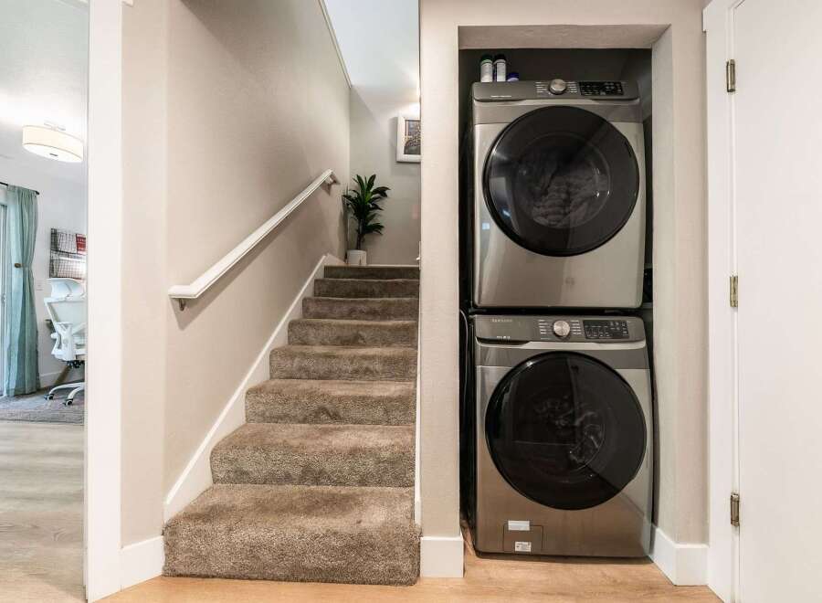 This home features a convenient stacked washer and dryer unit, perfect for maximizing space in a laundry area or hallway.