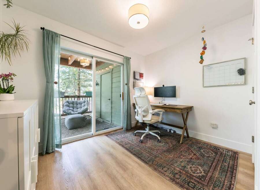 This home office features a large sliding glass door that opens to a private balcony, perfect for enjoying the outdoors.