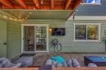 Enjoy outdoor entertainment with this covered patio featuring a mounted flat-screen TV and comfortable seating.