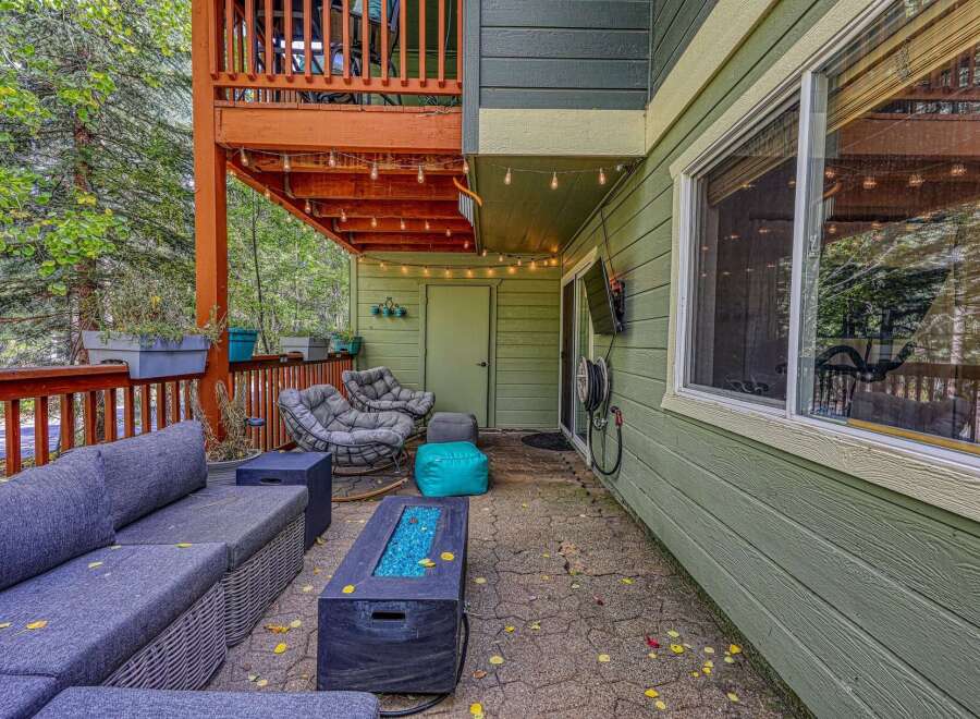 Enjoy outdoor living on this spacious patio, complete with a comfortable sectional sofa and a modern fire pit.