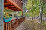 Enjoy the crisp autumn air from this charming home featuring a spacious upper deck and a cozy lower porch adorned with string lights.