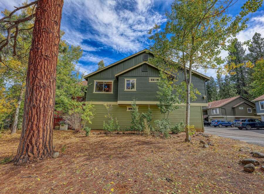 Nestled amidst a vibrant autumn landscape, this charming property boasts a rich green exterior, complemented by warm earth tones.
