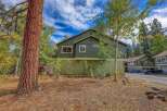 Nestled amidst a vibrant autumn landscape, this charming property boasts a rich green exterior, complemented by warm earth tones.