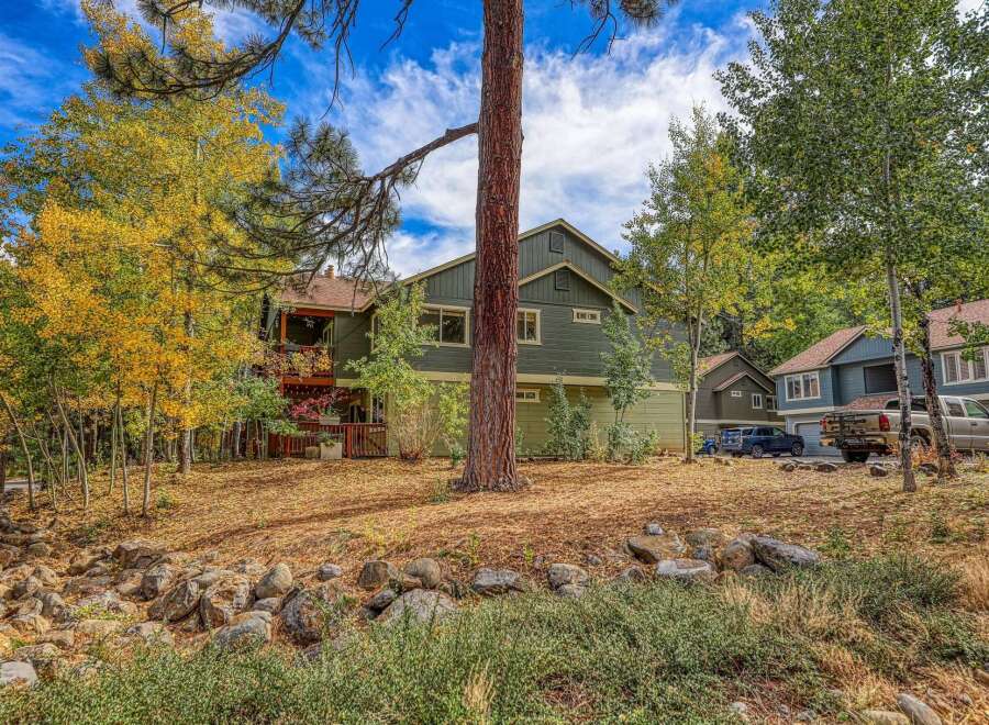 Nestled amidst vibrant autumn foliage, this charming property offers a serene retreat with its multi-level design and inviting outdoor spaces.